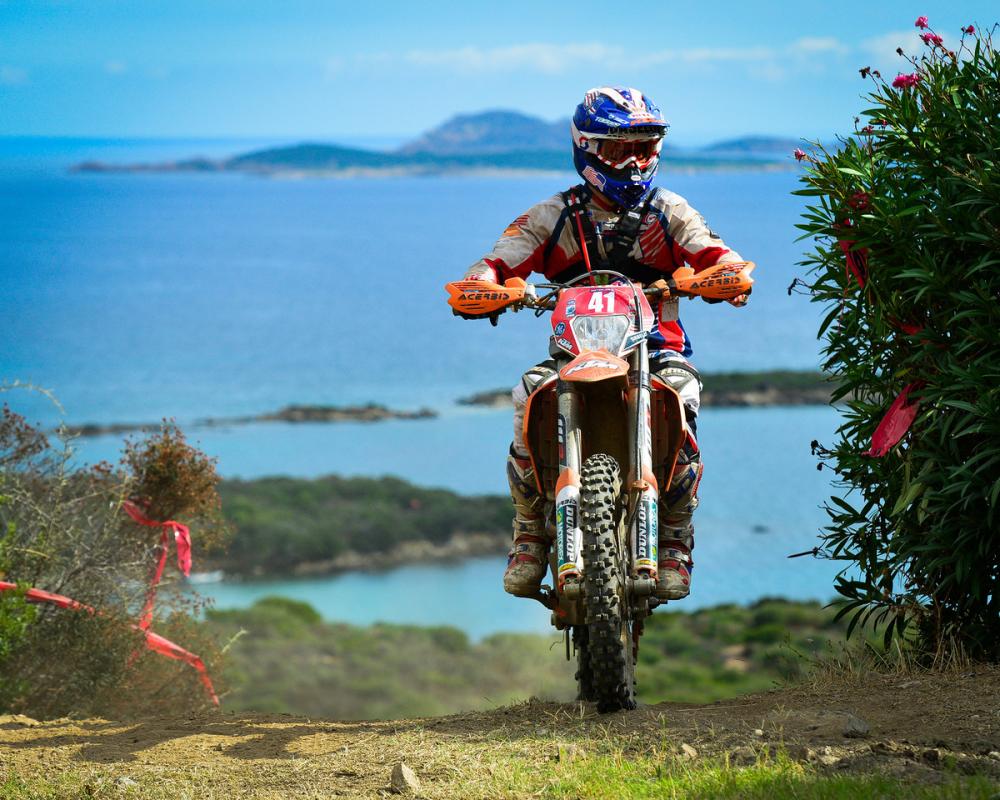 With the sparkling Mediterranean Sea in the background Kurt Caselli crests a hill during this year's Italian ISDE.