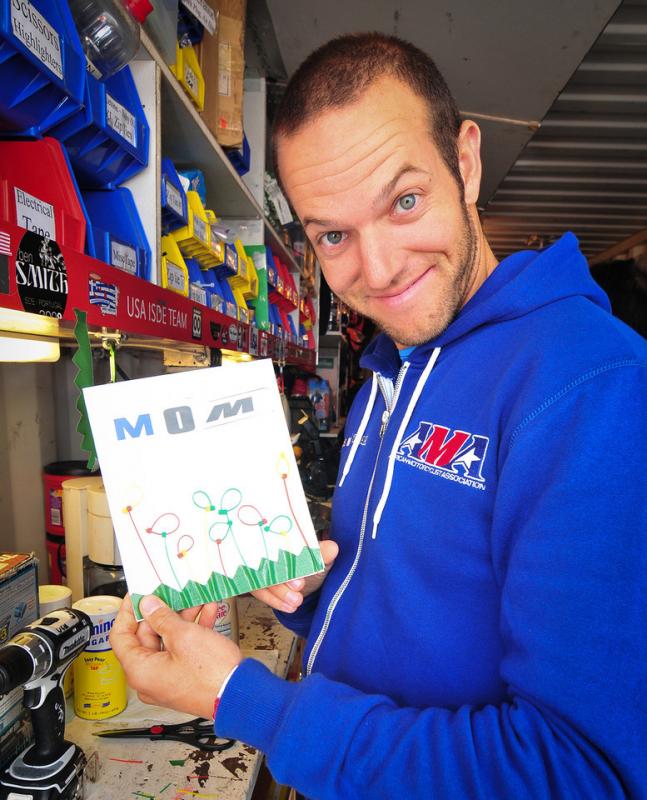 Kurt Caselli shows of a makeshift birthday card that he made for his mother's birthday during the German ISDE in 2012. The card consisted of green duct tape, zip-ties and letters cut from graphic kits.