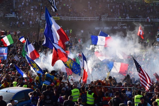 Security fight to hold back celebrating French fans from storming the podium at Maggiora.