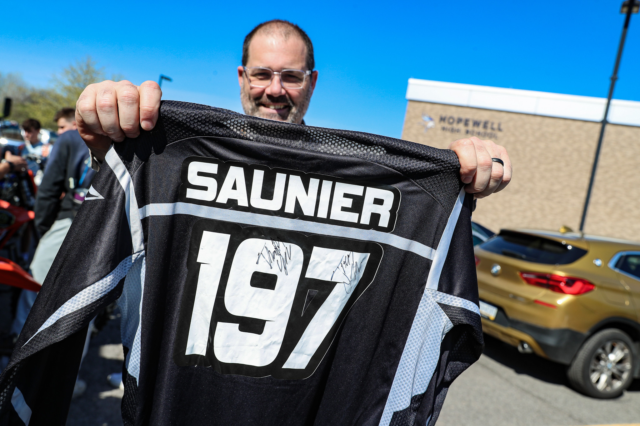 Mr. Collins holds up Brian Saunier Jr.'s signed jersey. Collins played a big factor in Saunier's time at Hopewell.