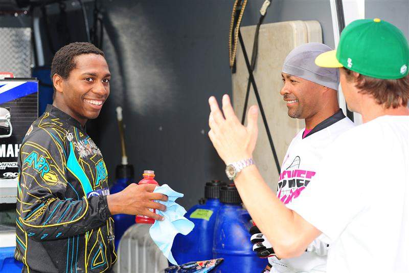 Stewart (left), his guy Rado (right, in the gray cap) and Answer's Roger Larsen (far right) talk over the on-track action.