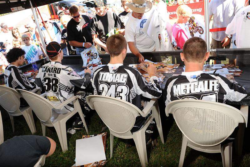 The GEICO Powersports Honda team signs for the fans.