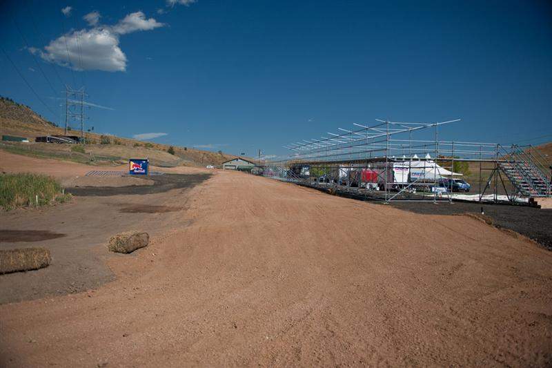 As you can see from this photo, the reason the start is moved up 20 or so feet from where it was is so that the finish-line jump will lead onto a straightaway that runs behind the starting gate, and that straightaway is where the mechanics pit-board and pit area will be (the structures on right). At the National, the racers make a hard left after the finish line and go back up the start hill. At the MXoN, they will go back up the start hill on the far right of the hill, at the end of this straightaway.
