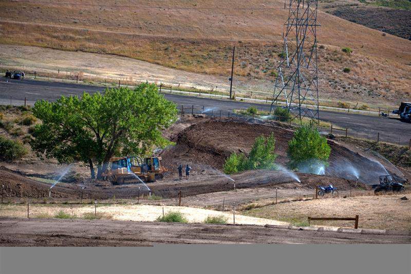 A closer view of the far side of the track while the sprinklers prepare the dirt.