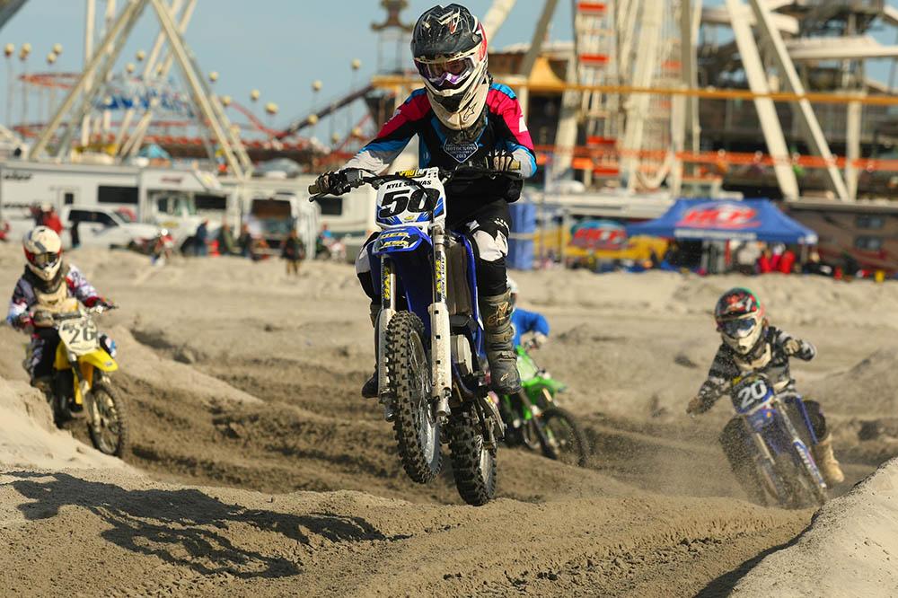 With the amusement rides in the background, Kyle Savvas (50) leads Karly Morgan (20) and Ryan Trevelise (26) in Junior Mini competition. / Scott Lukaitis photo 