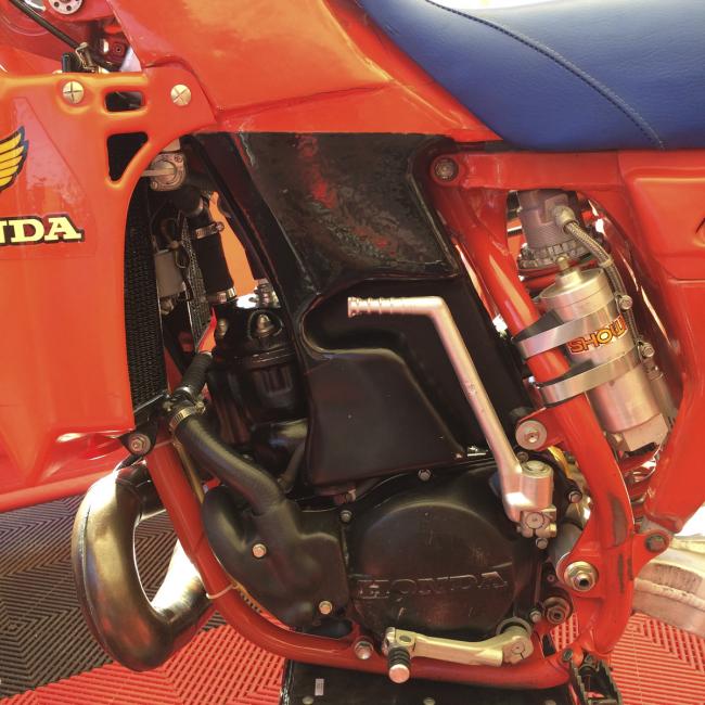 The black paint tries to hide how low, trick and non-production the tank is. Behind it sits a fuel pump to get fuel back up into the carb. Also, look at the welds near the upper shock mount and front subframe bolts. Hand made.