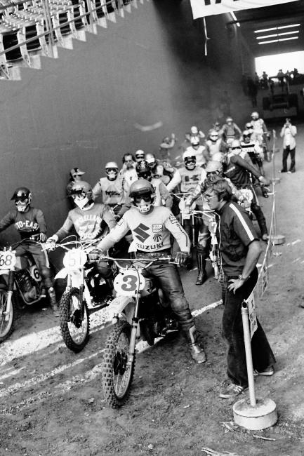 Tony DiStefano switched from CZ to Suzuki in 1975 but rode the 500 Class indoors (and his first factory mechanic standing on the right is current Yamaha boss Keith McCarthy).