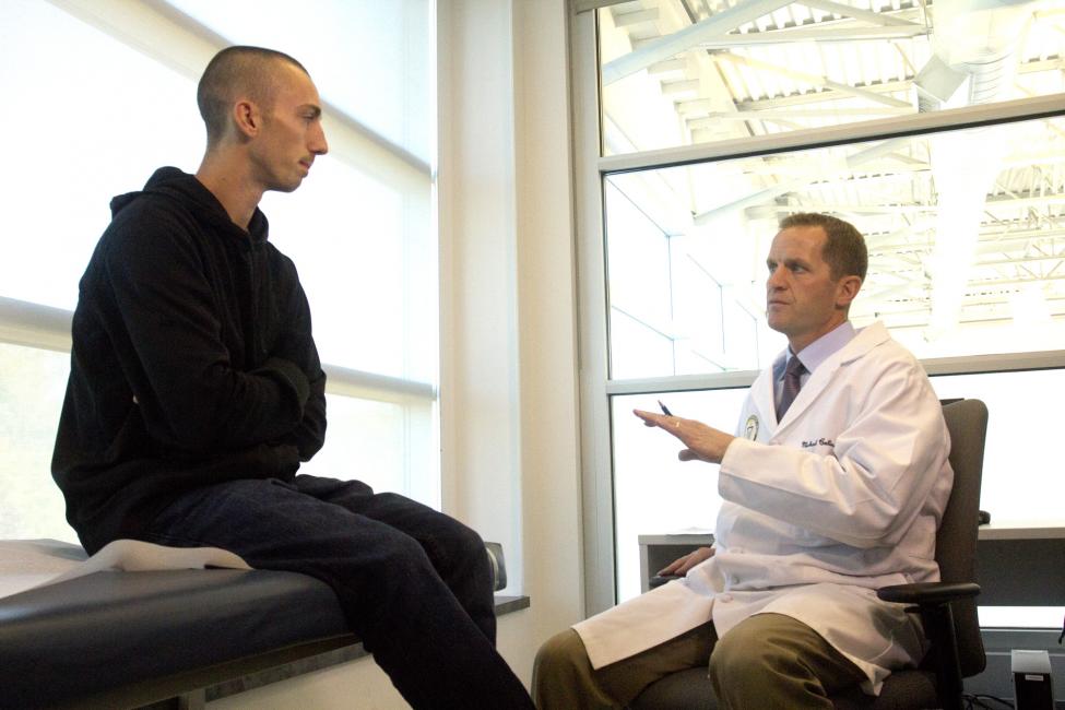 Doctor Michael Collins reviews test results with McDade. 