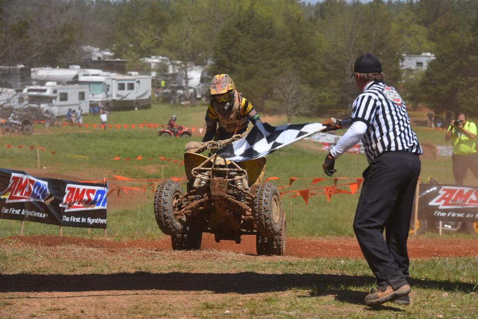 Hunter Hart, rider no. 211, grabs the checkers at an earlier round of GNCC Racing this year.  Hart will be competing on both ATVs and motorcycles this weekend at the inaugural Tomahawk GNCC in Odessa, New York.