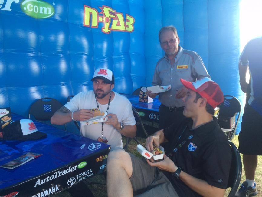 Weege, JR, and Tat from Pirelli enjoy a supercross dog.