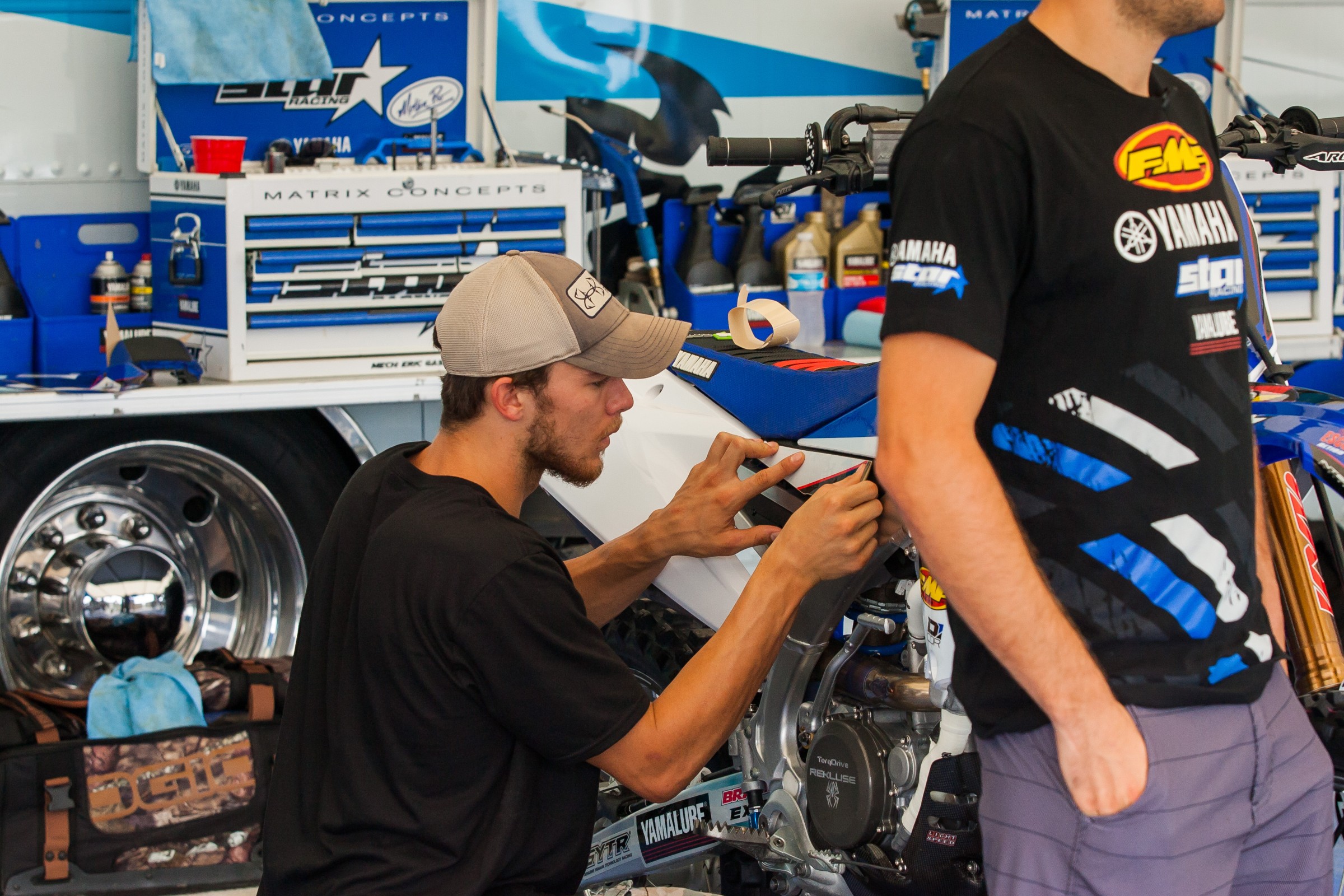 Aaron Plessinger have fun applying graphics to Webb's bike at press day.