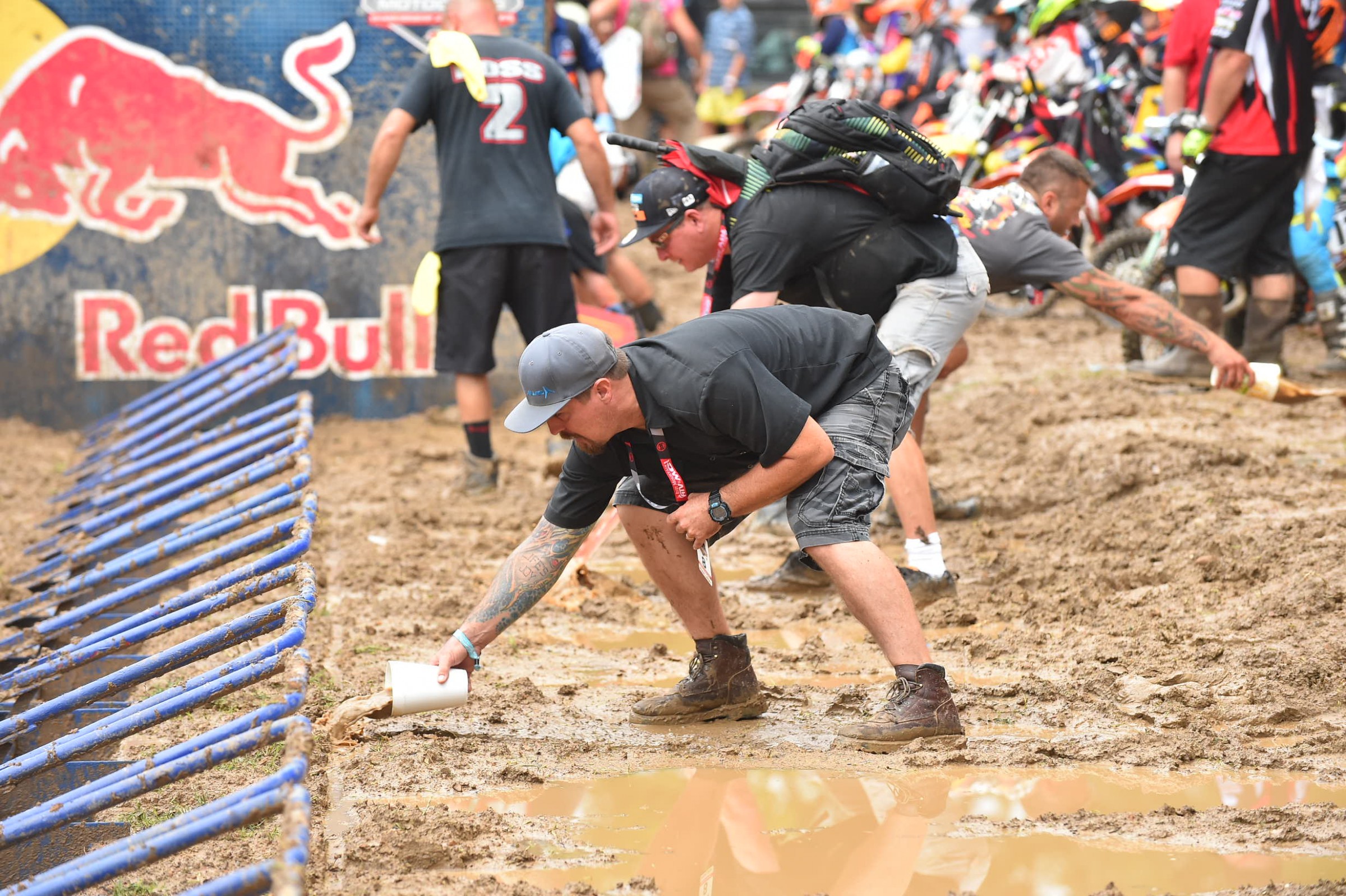 A father tries to clear water out of the starting gate yesterday morning.