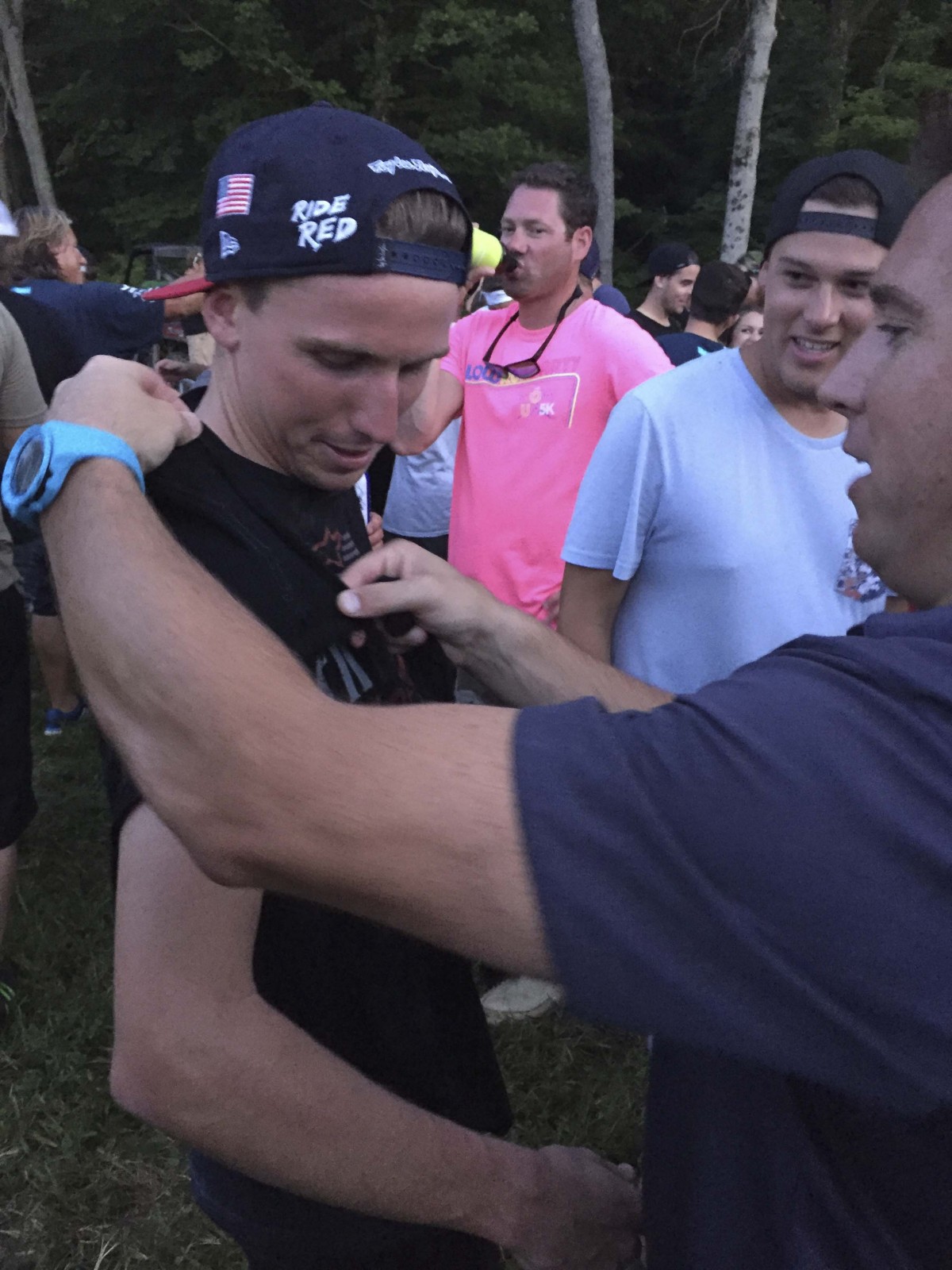 Grant Langston helped Cole Seely with his T-shirt tailoring at the barbecue/pit party after the Ironman National.