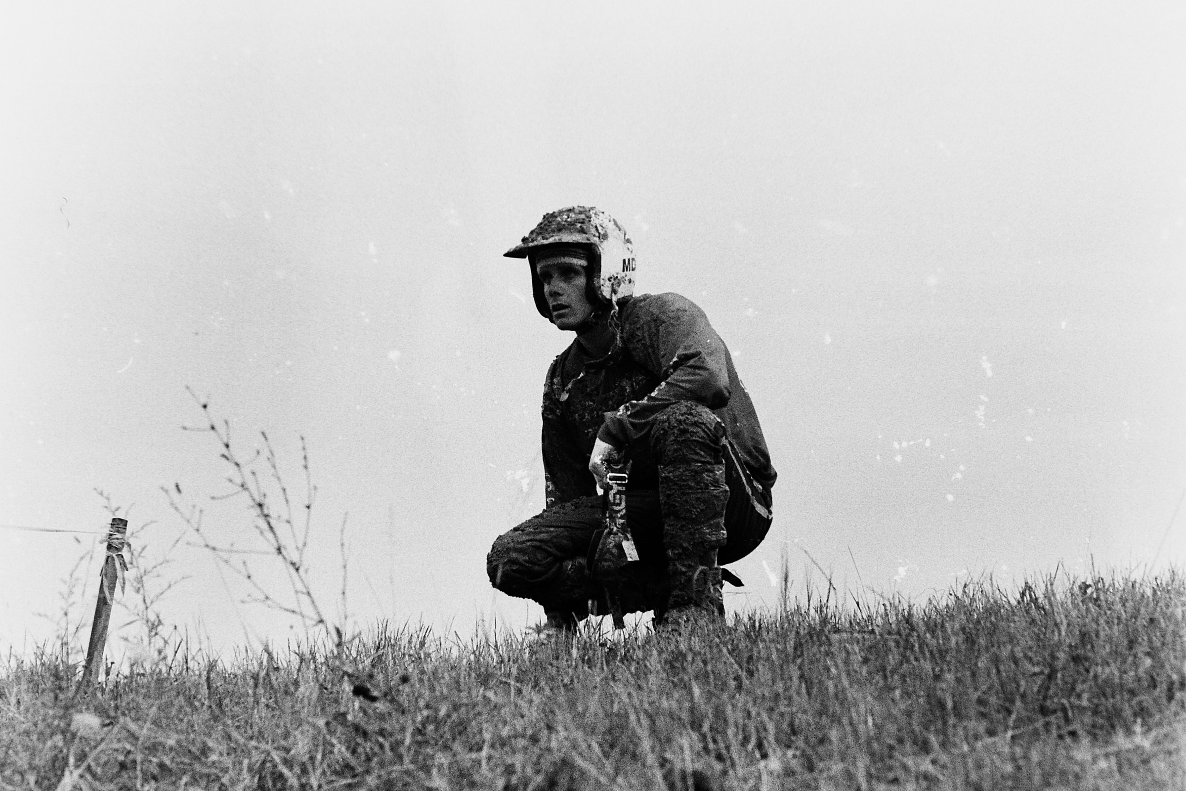 Michele Rinaldi kneels in the infield after he had to have his bike taken apart to get his leg out from between the swing arm and the rear wheel of his Gilera.