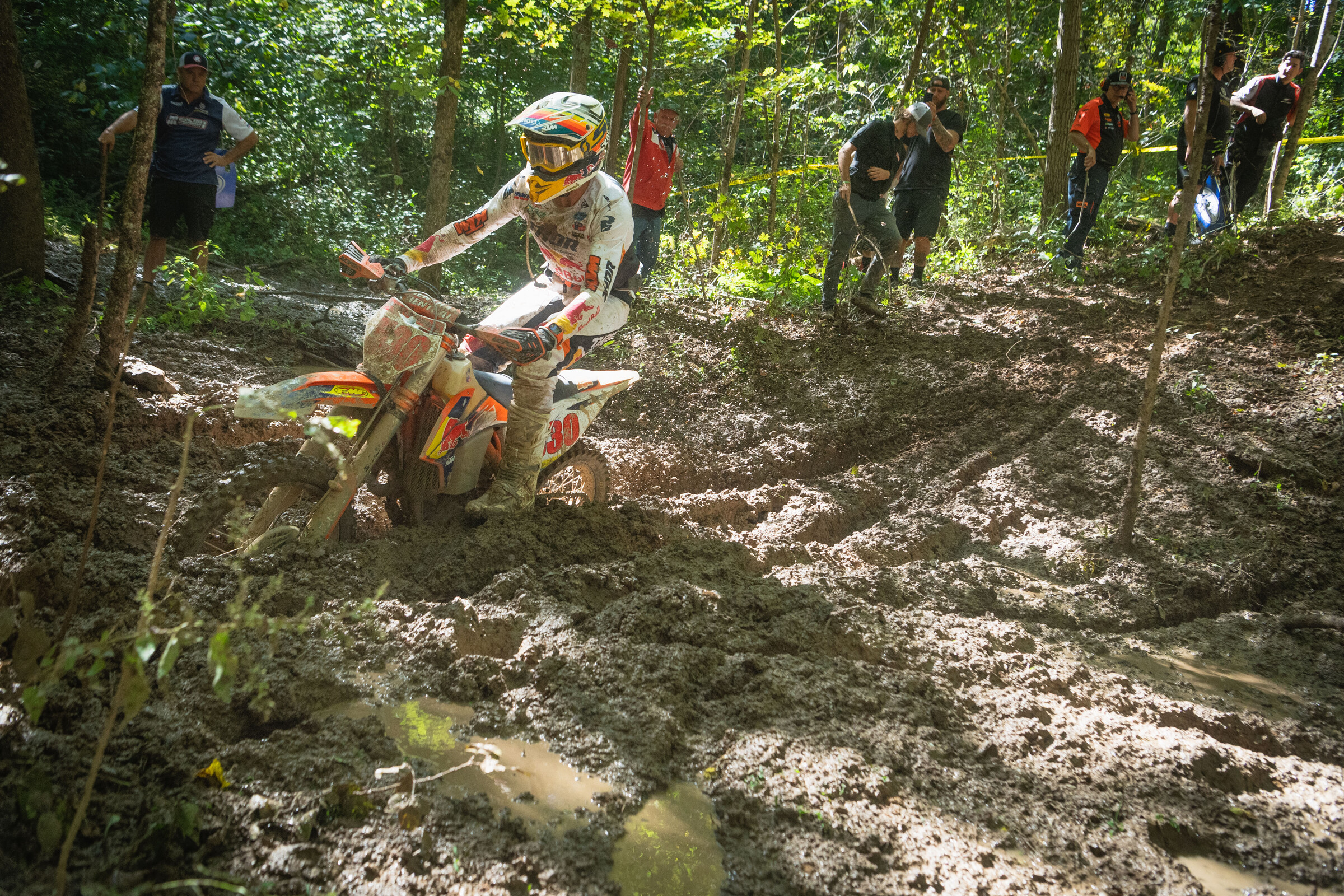 Ben Kelley navigates through mud in the woods.
