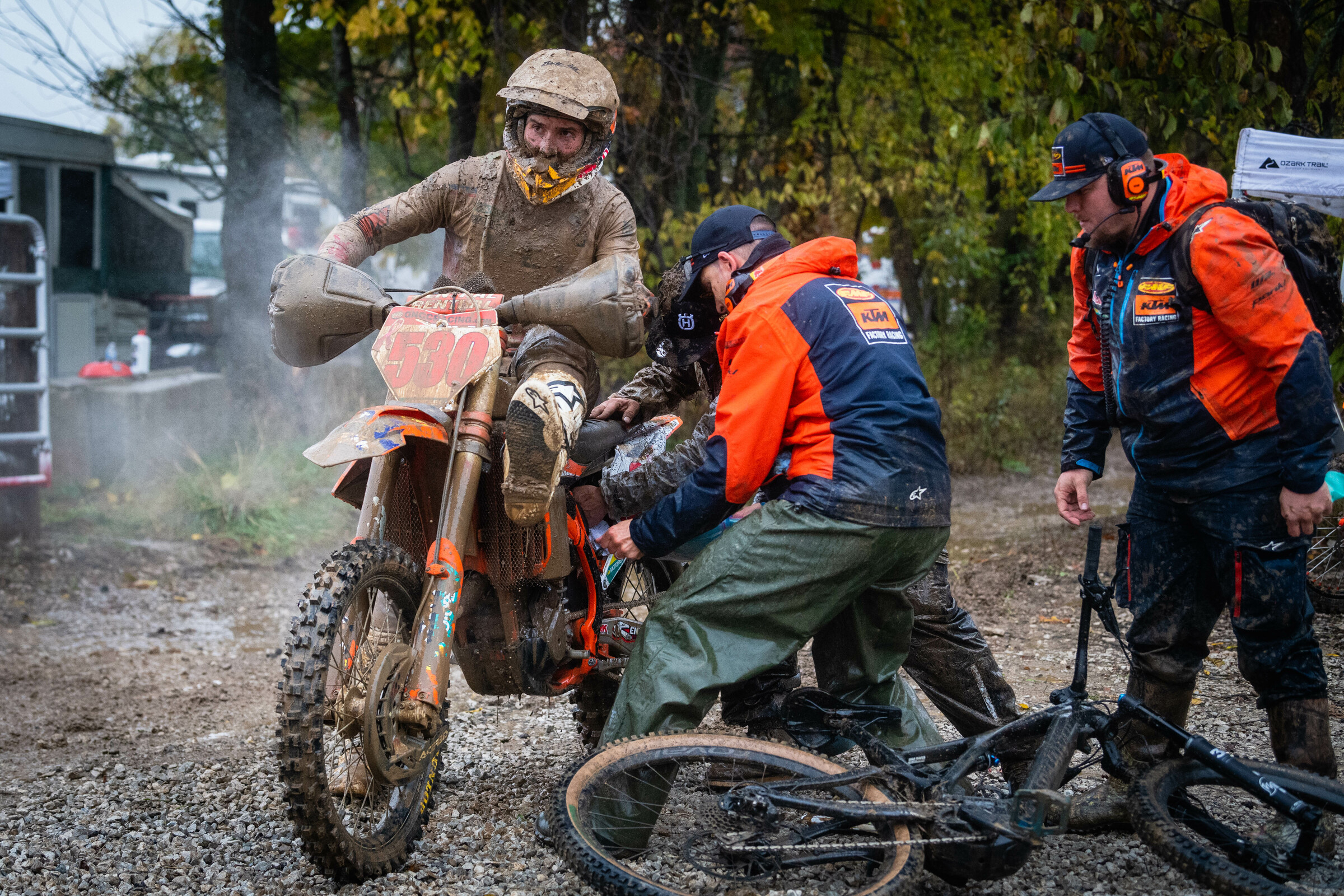 Ben Kelley holds his foot up as the KTM team works on his air filter mid-race.