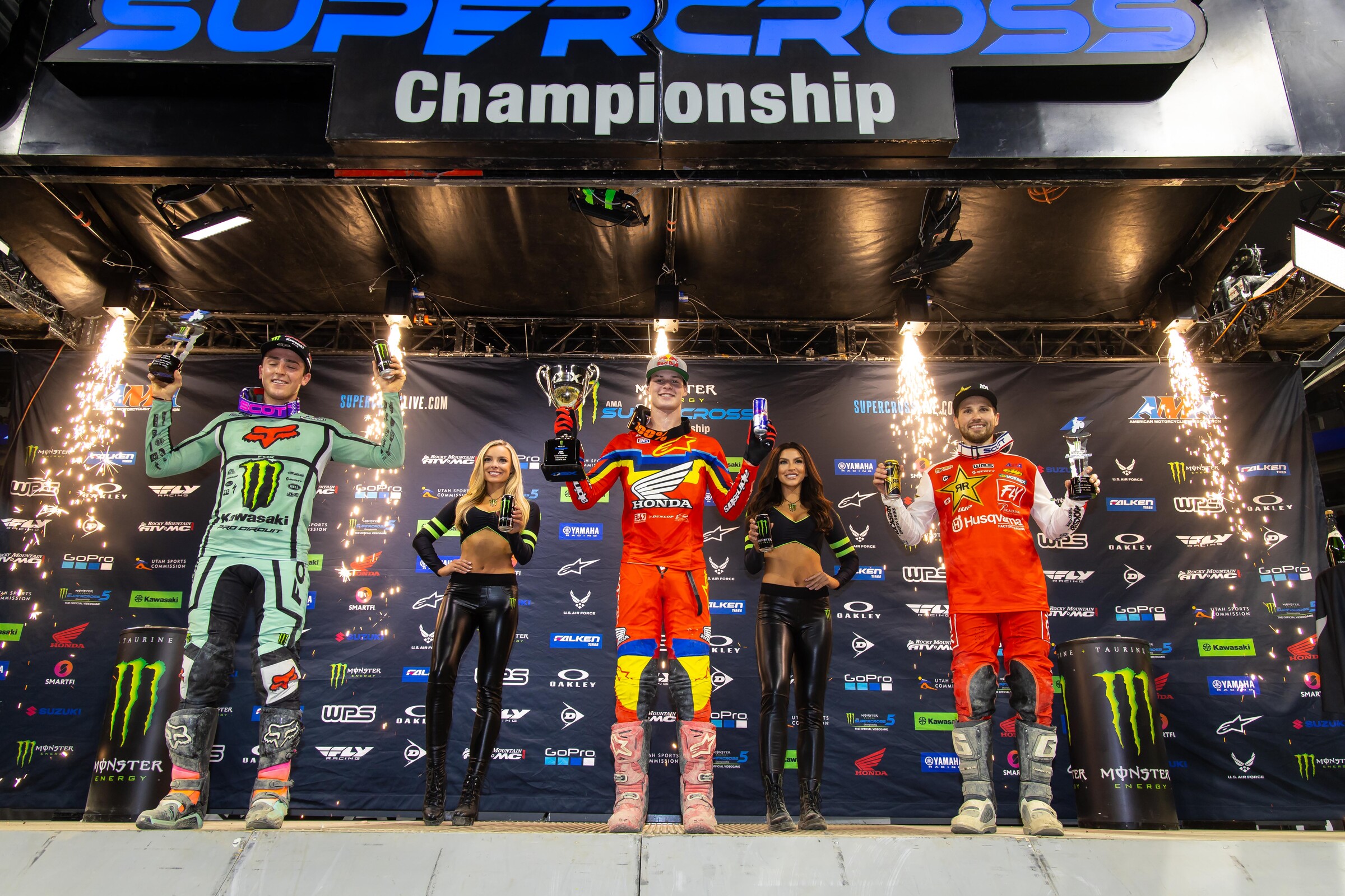 The 2022 Indianapolis Supercross 250SX podium: Jett Lawrence (center, first), Cameron McAdoo (left, second), and RJ Hampshire (right, third).