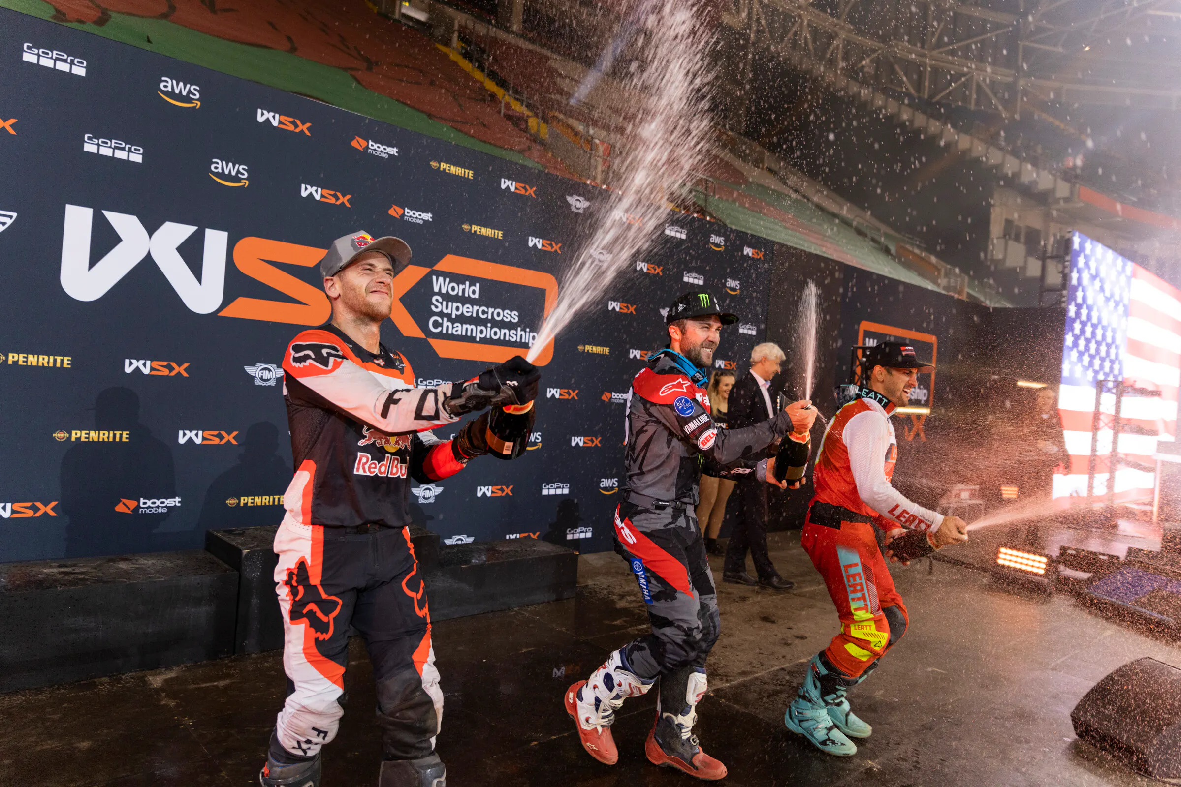 Roczen, winner Eli Tomac, and Vince Friese spray champagne on the podium.