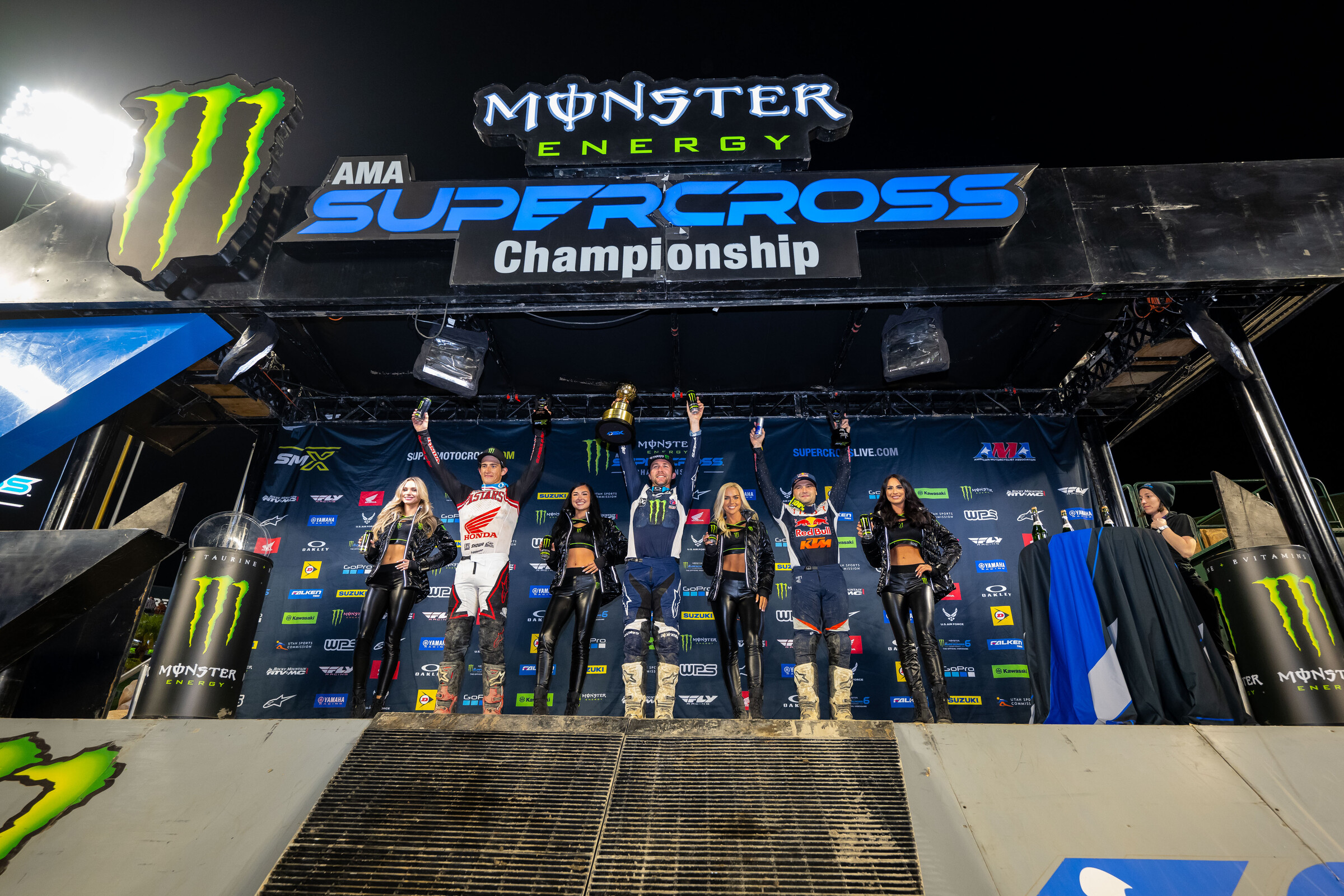 The 2023 Anaheim 1 Supercross 450SX main event podium: Eli Tomac (Yamaha), Cooper Webb (KTM), and Chase Sexton (Honda).