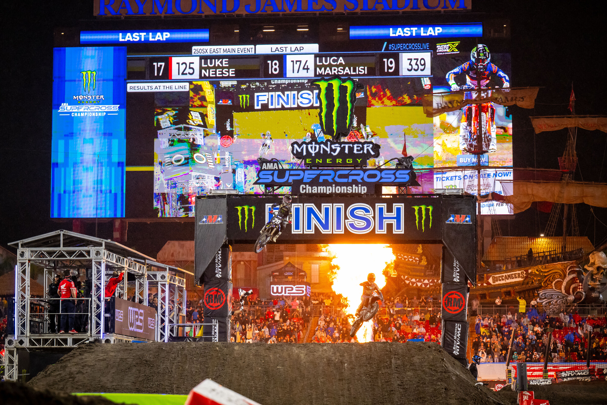 Hunter Lawrence (bottom right in front of flame) barely crosses the finish line ahead of Nate Thrasher at the checkered flag in the 250SX main event. Lawrence won by 0.134 seconds in a last-lap come-from-behind win.