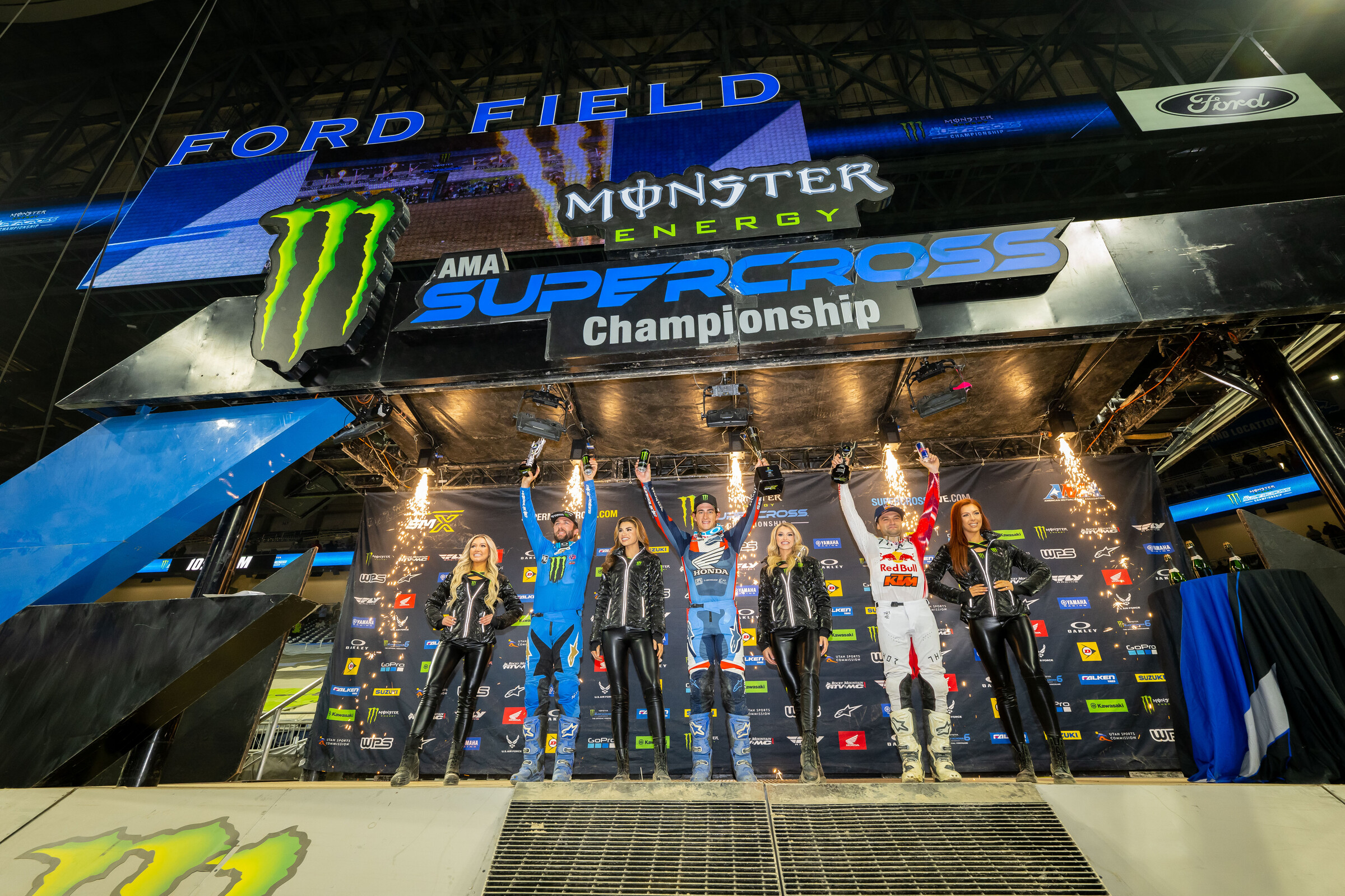 The 2023 Detroit Supercross 450SX main event podium: Chase Sexton (Honda), Cooper Webb (KTM), and Eli Tomac (Yamaha).