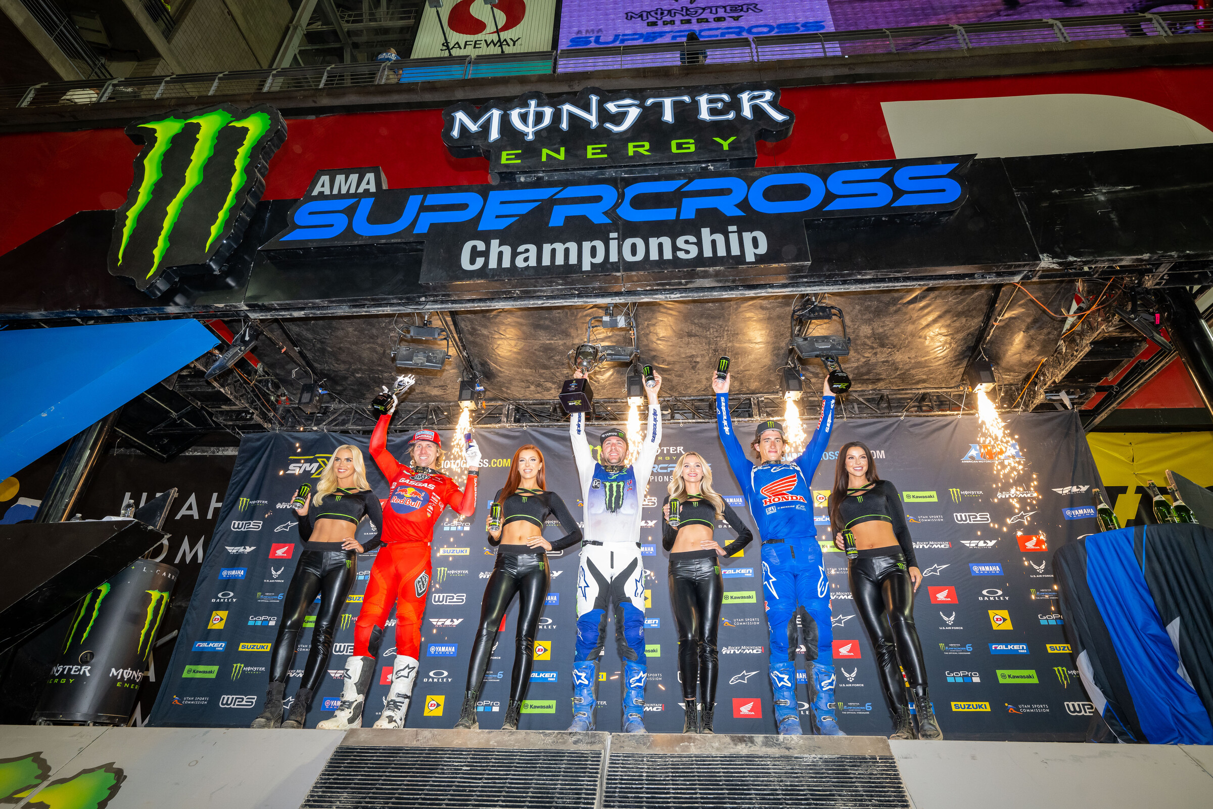The Glendale Supercross Triple Crown 450SX overall podium: Eli Tomac (center, first overall), Chase Sexton (right, second overall), and Justin Barcia (left, third overall).